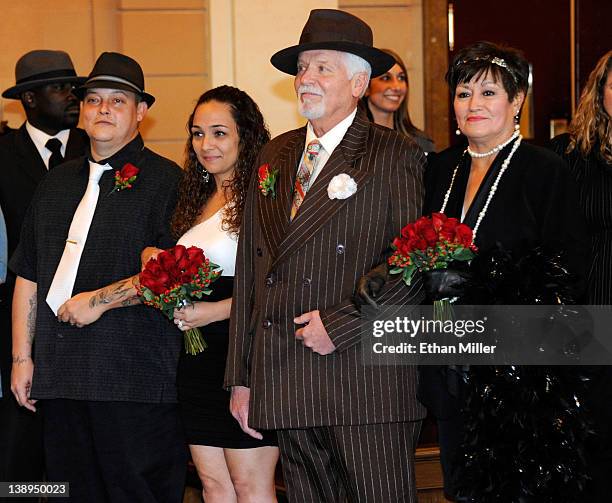 Troy Weekley and Cynthia Weekley of California, and Thomas Luginbill and Victoria Luginbill of Washington renew their wedding vows in a courtroom...