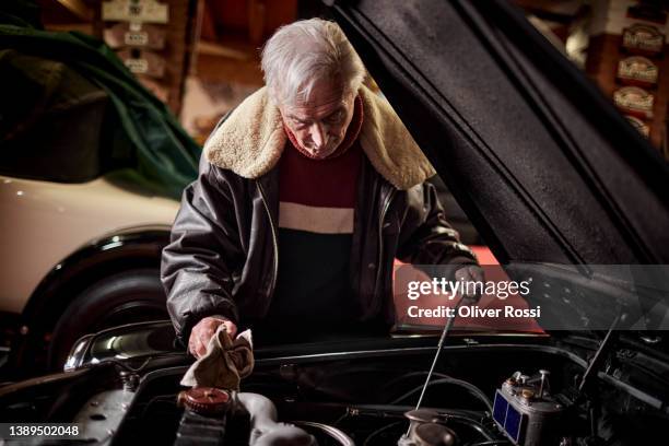 senior man working on classic vintage car in garage - dipstick stock pictures, royalty-free photos & images