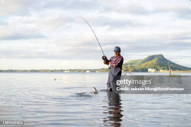 male fishing at sunset on lake - freshwater fishing stock pictures, royalty-free photos & images