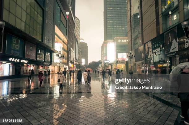 view of the main shopping street in chongqing's center on a rainy day - asia rain stock pictures, royalty-free photos & images