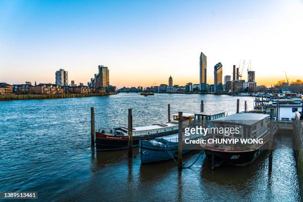 old boats by the river thames, with modern buildings in chelsea london - fulham v chelsea stock pictures, royalty-free photos & images