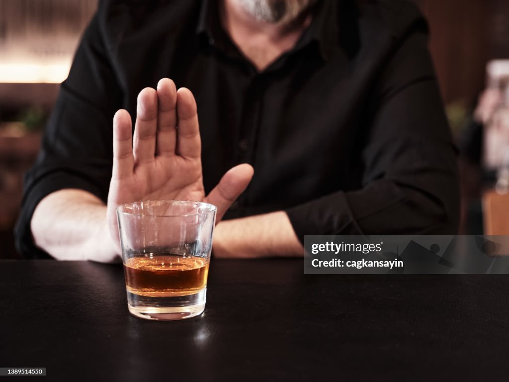 Man refuses or rejects to drink alcohol at the pub.