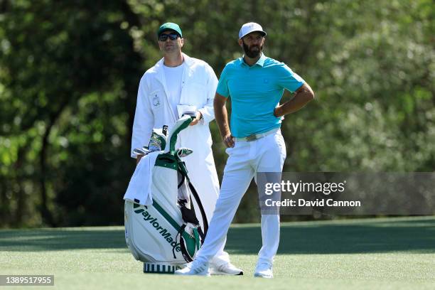 Dustin Johnson of the United States and caddie Austin Johnson look on over the 11th hole during a practice round prior to the Masters at Augusta...