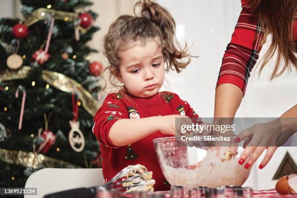 a girl is frustrated because she does not know how to knead while her mother teaches her - christmas stress stock pictures, royalty-free photos & images