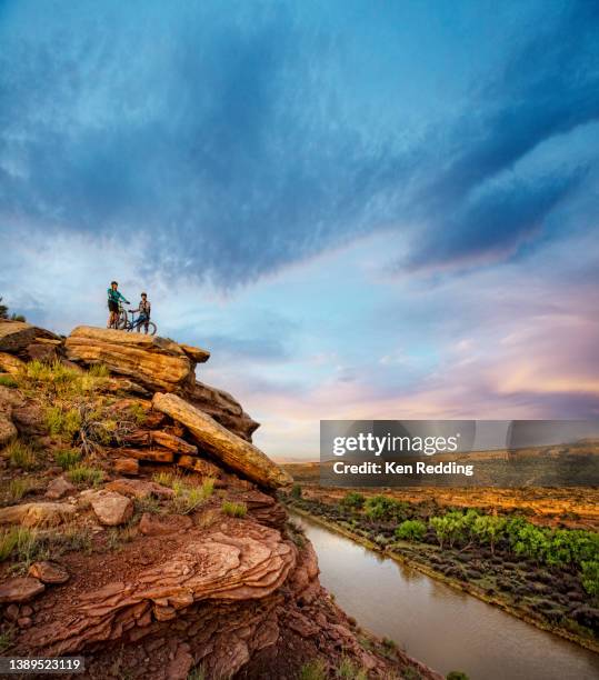 a young couple is out for a mountain bike ride with their dog - fruita colorado stockfoto's en -beelden