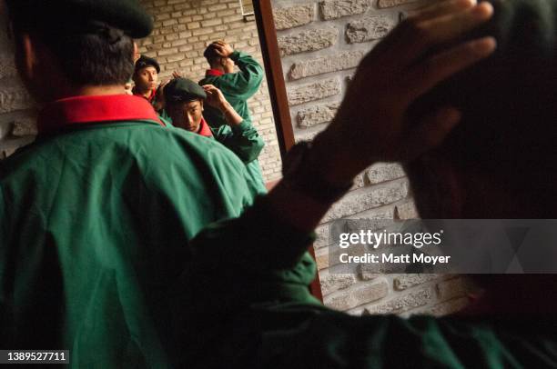 Young Nepalese men try on new berets after being chosen to become members of the famed British Gurkhas in Pokhara, Nepal on December 6, 2005. Every...