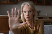 Worried mature Caucasian lady making hand stop gesture