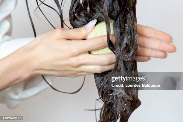 woman using solid soap washing hair with shampoo bar - shampoo stock-fotos und bilder