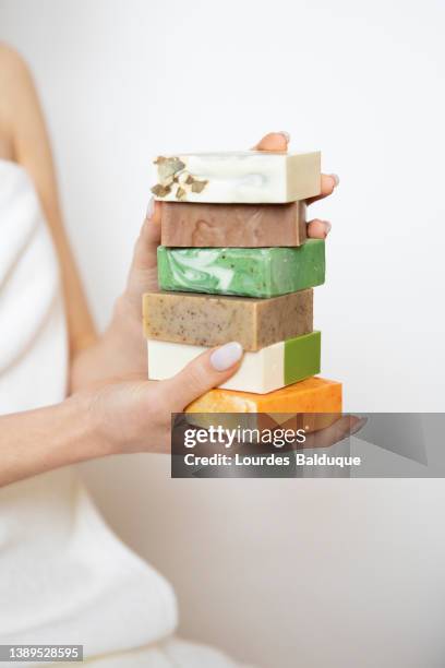 woman's hand holding handmade soaps - white bar of soap stock pictures, royalty-free photos & images