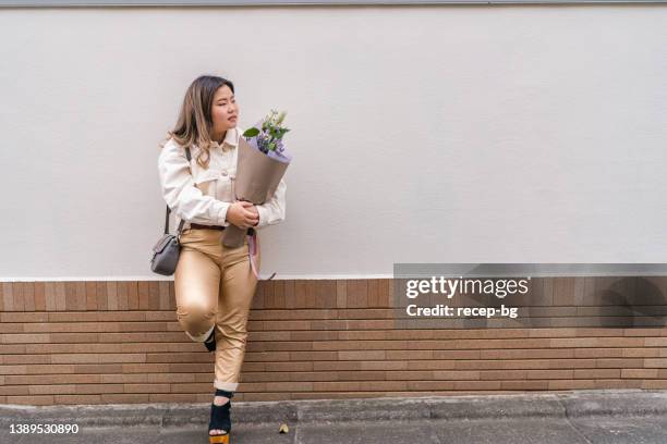 full length portrait of beautiful woman holding flowers - plus size fashion stock pictures, royalty-free photos & images