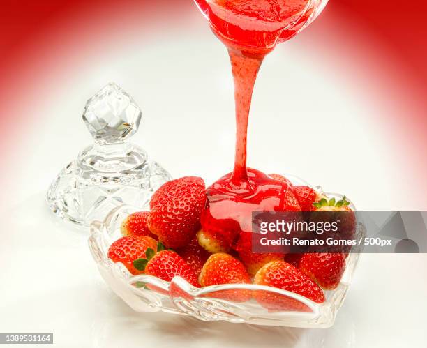 close-up of strawberry sauce pouring in glass on table - sobremesa stock pictures, royalty-free photos & images