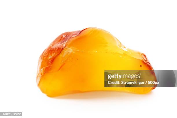 natural amber a piece of yellow opaque natural amber on white - amber stockfoto's en -beelden