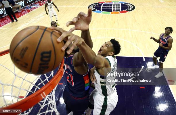 Giannis Antetokounmpo of the Milwaukee Bucks dunks past Joel Embiid of the Philadelphia 76ers during the first quarter at Wells Fargo Center on March...