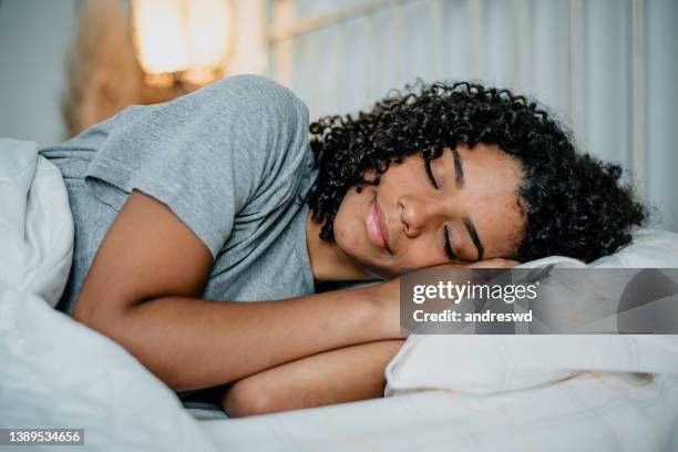 teenager sleeping in bed - slapen stockfoto's en -beelden