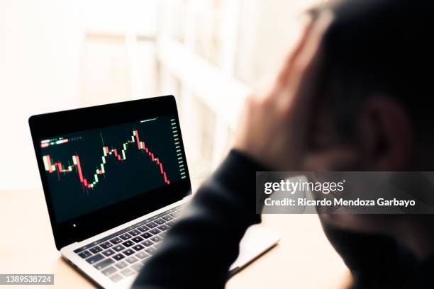 pensive and sad man watching the graph crash - deterioration stock pictures, royalty-free photos & images