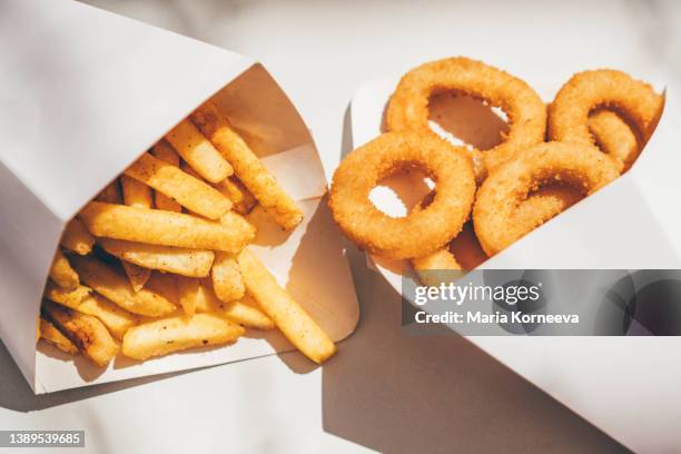 deep-fried onion rings  and french fries. - deep fried bildbanksfoton och bilder