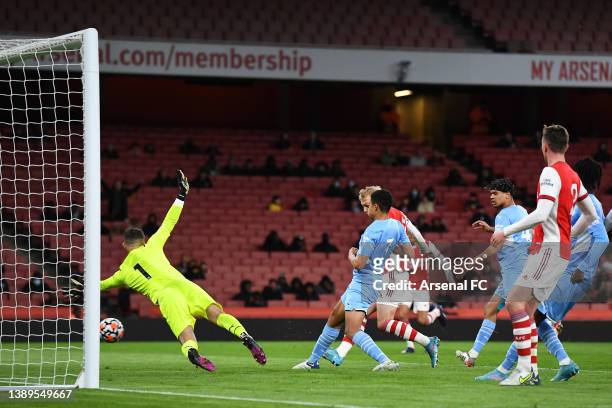 Mika Biereth of Arsenal scores their team's second goal under pressure from Shea Charles of Manchester City during the Premier League 2 match between...