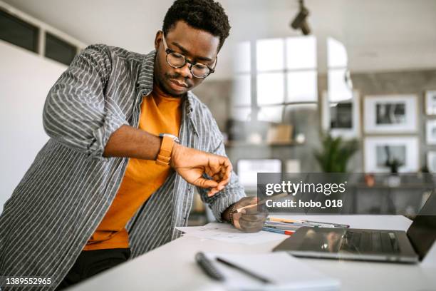 young architect working in the office - checking the time stock pictures, royalty-free photos & images