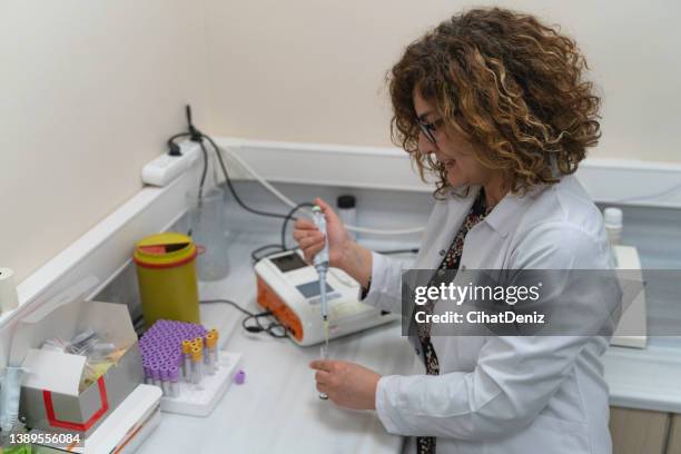 kadın sağlık çalışanı laboratuvarda çalışırken görüntüsü - labor zentrifuge stock pictures, royalty-free photos & images