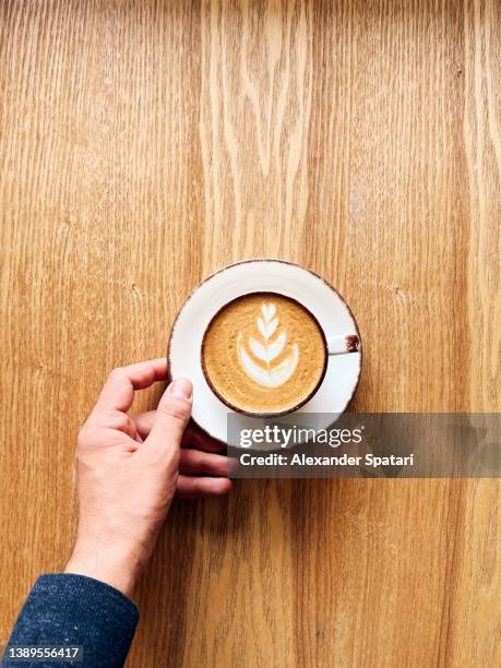 man drinking latte at the coffee shop, directly above personal perspective view - coffee art stockfoto's en -beelden