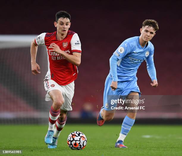 Charlie Patino of Arsenal runs with the ball under pressure from James McAtee of Manchester City during the Premier League 2 match between Arsenal...