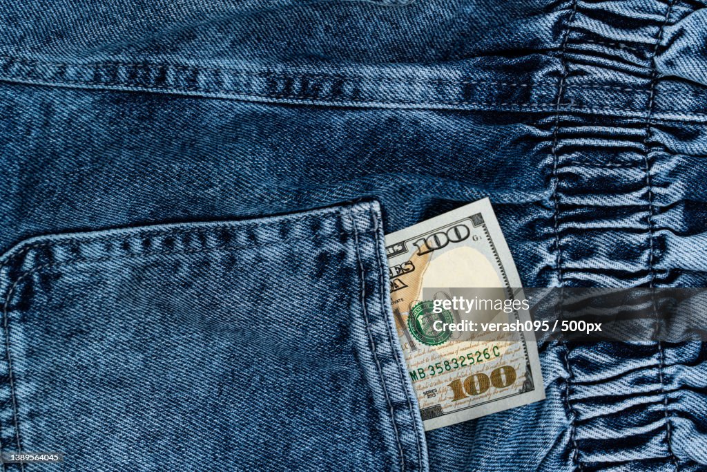 One hundred dollar bills in the back pocket of jeans