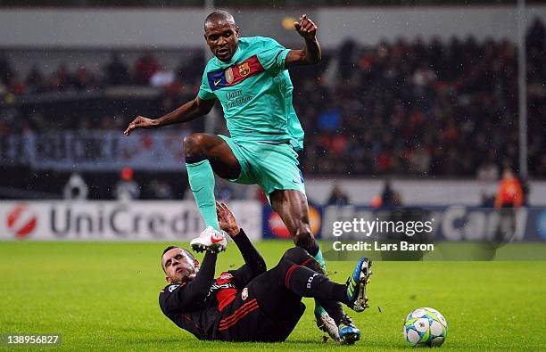 Renato Augusto of Leverkusen challenges Eric Abidal of Barcelona during the UEFA Champions League round of 16 first leg match between Bayer 04...