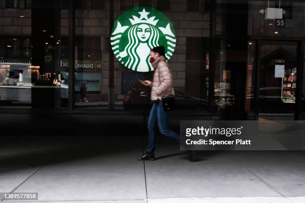 Woman walks by a Starbucks coffee shop in Manhattan on April 04, 2022 in New York City. JPMorgan CEO Jamie Dimon has warned in his annual shareholder...