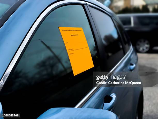 wheel clamp: bright orange immobilization notice sticker on parked car - department of motor vehicles stock pictures, royalty-free photos & images