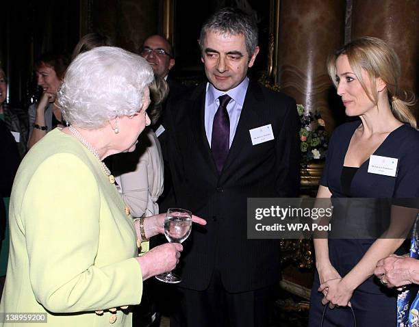 Queen Elizabeth II meets actor Rowan Atkinson and actress Gillian Anderson at a reception to celebrate the 200th anniversary of the year Charles...