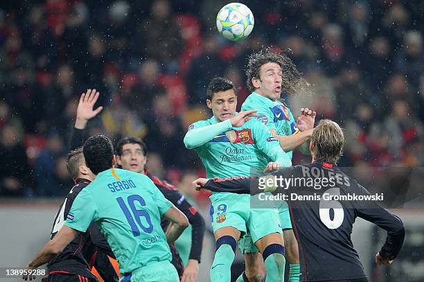 Alexis Sanchez of Barcelona and teammate Carles Puyol jump for a header during the UEFA Champions League round of sixteen first leg match between...