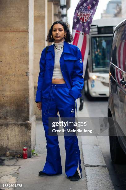 Model Neva Akdag wears a matching BENKLARK blue jacket and sports pants, tan crop top, black sneakers after the Gauchere show during Paris Fashion...