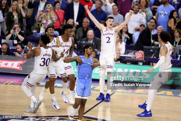 Christian Braun, K.J. Adams and Remy Martin of the Kansas Jayhawks celebrate after defeating the North Carolina Tar Heels to win the 2022 NCAA Men's...