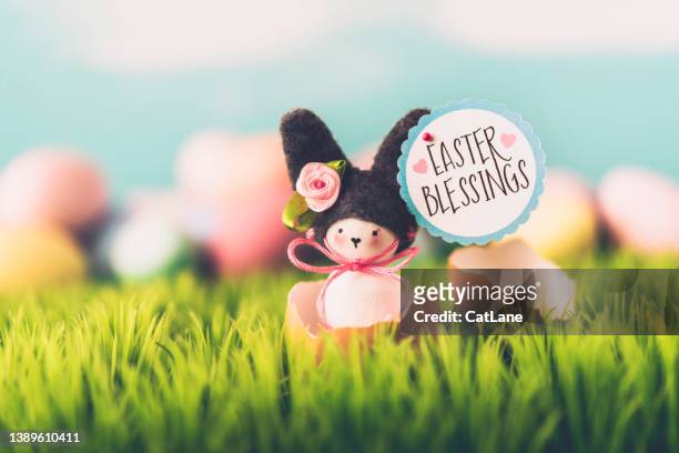 イースターの背景には、イースターの祝福と書かれた看板が付いた壊れた卵の殻にかわいい手作りのイースターバニーが - easter bunny ears ストックフォトと画像