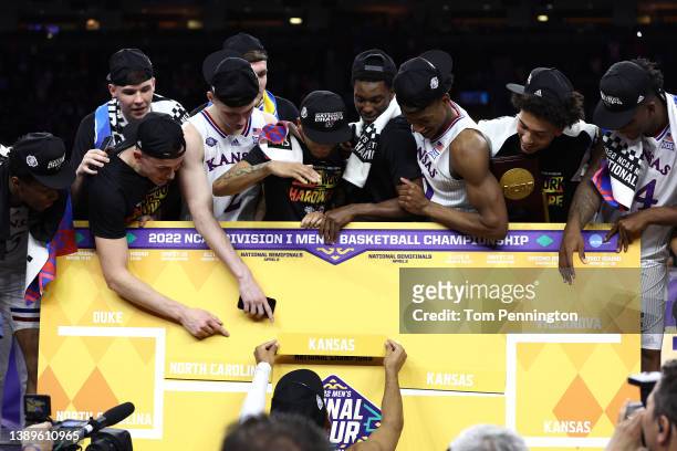 Kansas Jayhawks players place the team in the center of the bracket after defeating the North Carolina Tar Heels 72-69 during the 2022 NCAA Men's...