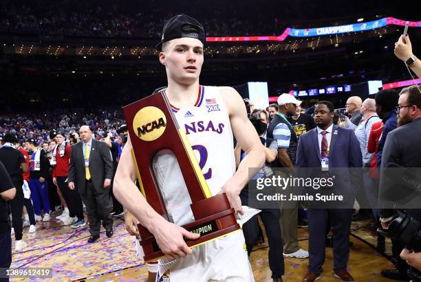 Christian Braun of the Kansas Jayhawks poses for a photo with the championship trophy after defeating the North Carolina Tar Heels 72-69 during the...