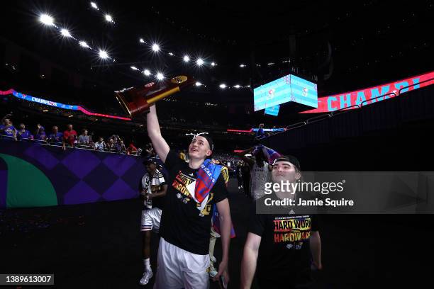 Mitch Lightfoot of the Kansas Jayhawks holds up the championship trophy after defeating the North Carolina Tar Heels 72-69 during the 2022 NCAA Men's...