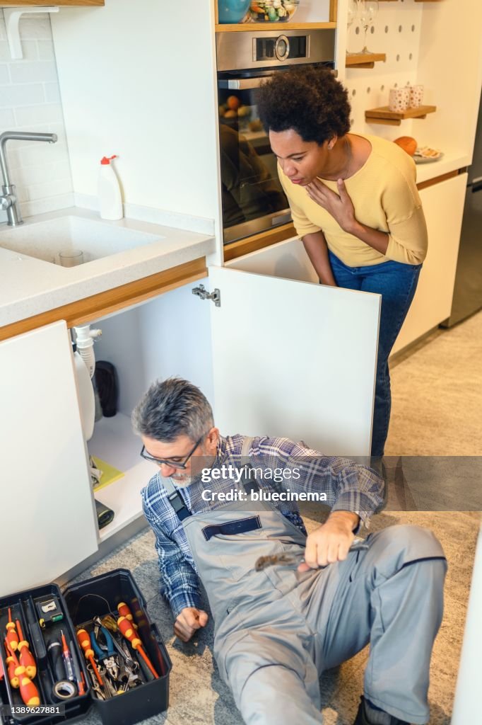 Plumber fixing kitchen sink