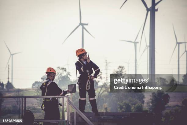 close up professional wind turbine maintenance team wearing ppe and safety harness walk working in wind turbine farm, green and renewable energy concept - wind power city stock pictures, royalty-free photos & images