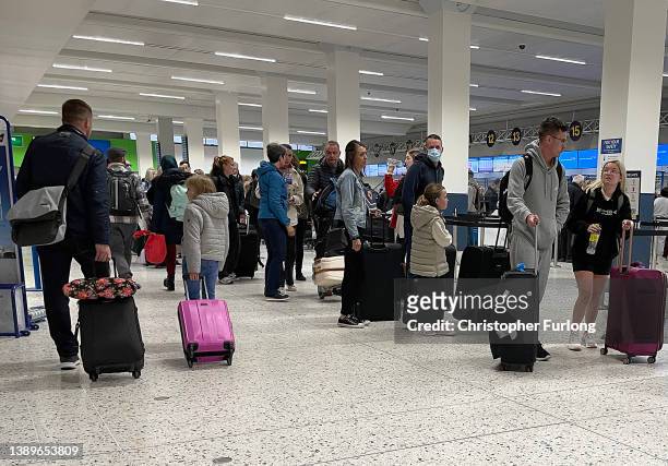 Passengers queue for check in at Manchester Airport's terminal 1 on April 05, 2022 in Manchester, United Kingdom. Covid checks, high passenger...