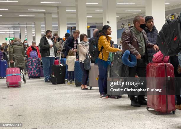 Passengers queue for check in at Manchester Airport's terminal 1 on April 05, 2022 in Manchester, United Kingdom. Covid checks, high passenger...