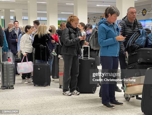Passengers queue for check in at Manchester Airport's terminal 1 on April 05, 2022 in Manchester, United Kingdom. Covid checks, high passenger...