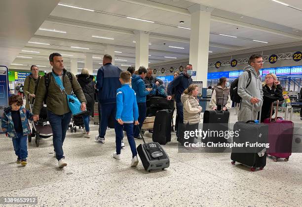Passengers queue for check in at Manchester Airport's terminal 1 on April 05, 2022 in Manchester, United Kingdom. Covid checks, high passenger...