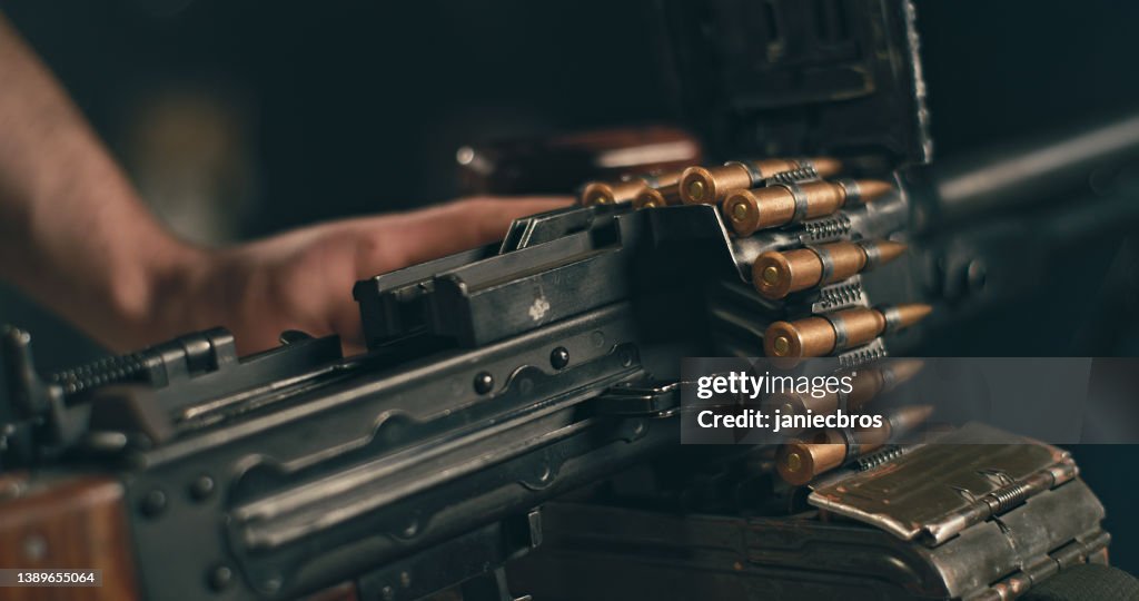 Professional shooter loading and preparing to use heavy PKM machine gun