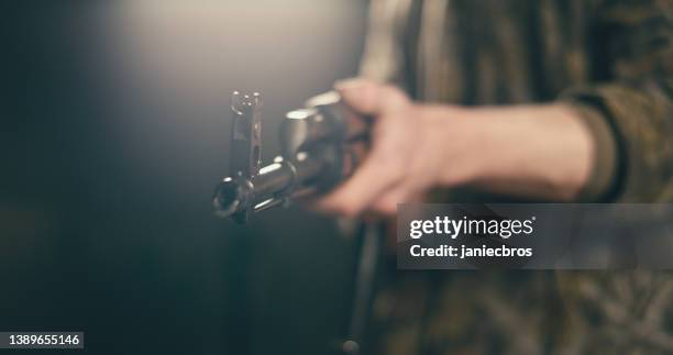 professional shooter aiming machine gun towards camera - kalasjnikov stockfoto's en -beelden