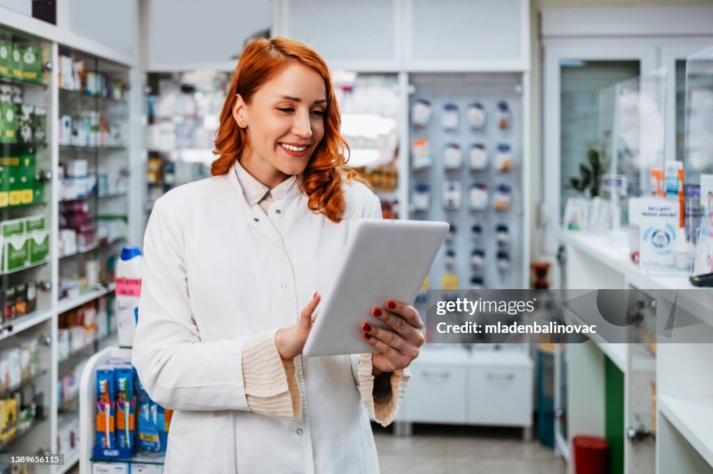 Retrato de um trabalhador de sorriso dos cuidados médicos na farmácia moderna.