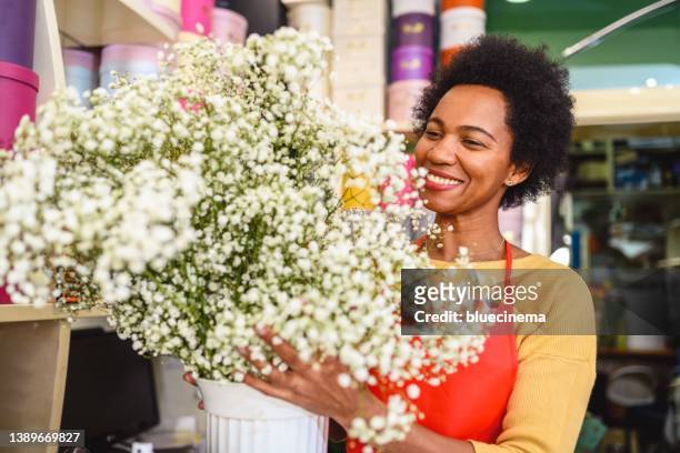 african-american woman working in flower shop - reopening ceremony stock pictures, royalty-free photos & images