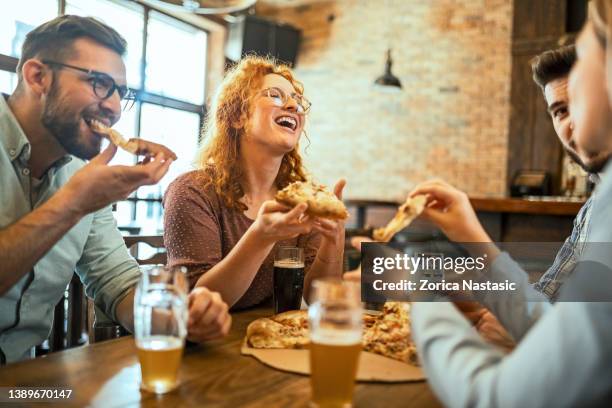 group of people eating pizza having good time - 30s woman eating stock pictures, royalty-free photos & images