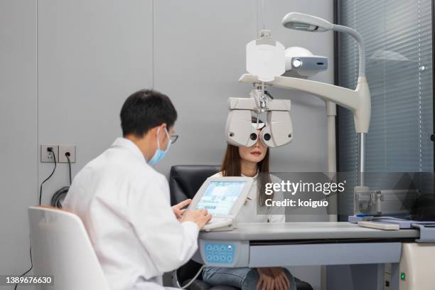 ophthalmologist checking eyesight of female patient - eye scan stock pictures, royalty-free photos & images