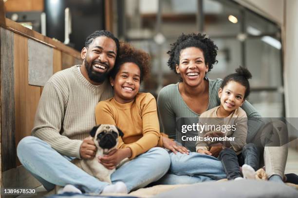 happy african american family and their dog enjoying at home. - familie stockfoto's en -beelden